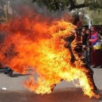 epa03159576 A Tibetan exile runs after setting fire to himself in New Delhi during a protest  against Chinese President Hu Jintao's upcoming visit in New Delhi, India on 26 March 2012. The unidentified young man doused himself with inflammable liquid before immolating himself among a group of around 1,000 protesters near the parliament street of Central Delhi.  EPA/HARISH TYAGI